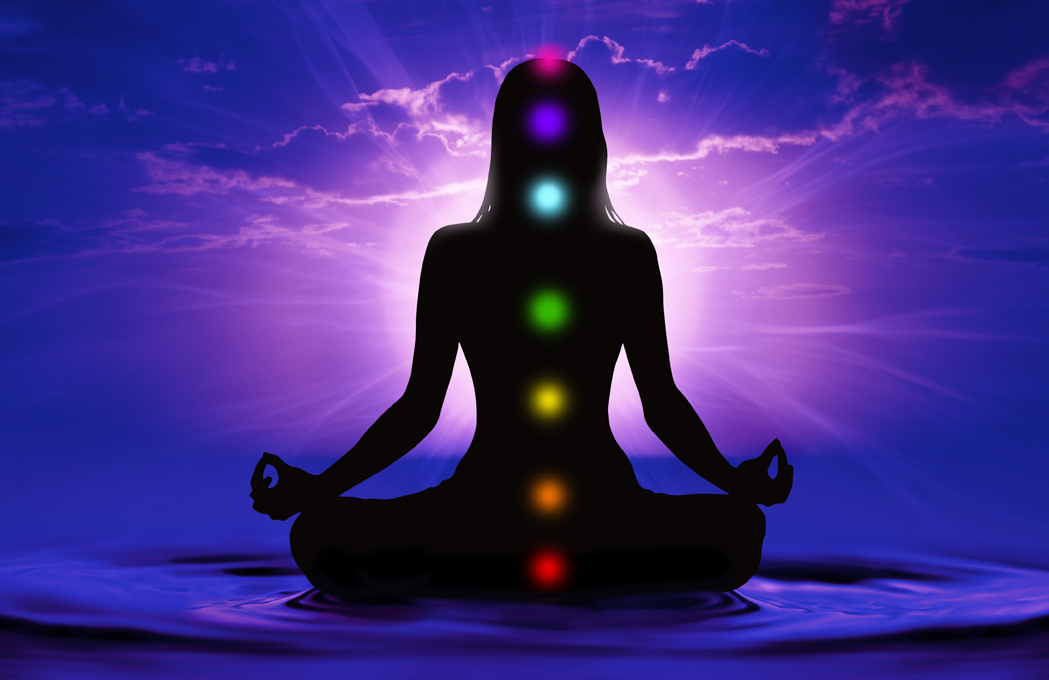 Silhouette of woman doing yoga and where has scored seven chakra points